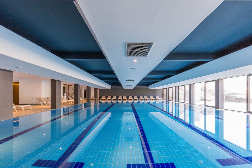 Spacious indoor swimming pool with ventilation system, showcasing energy-efficient air handling units for optimal temperature and humidity control.